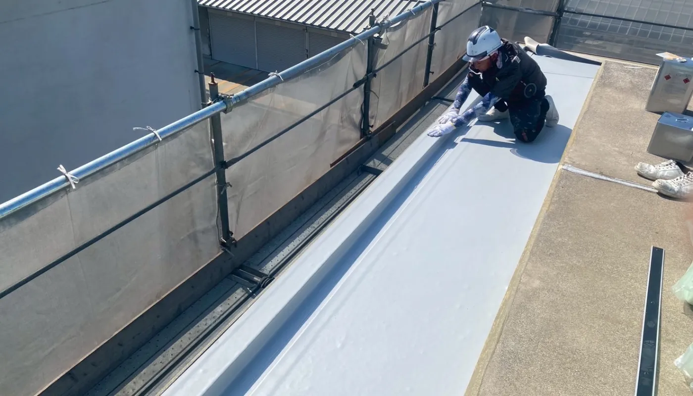 作業員が防水工事をしているところ